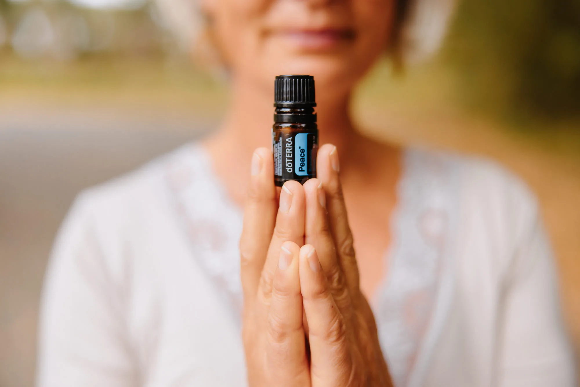 Close-up of a woman’s hands with the wonderful dōTERRA essential oil “Peace”